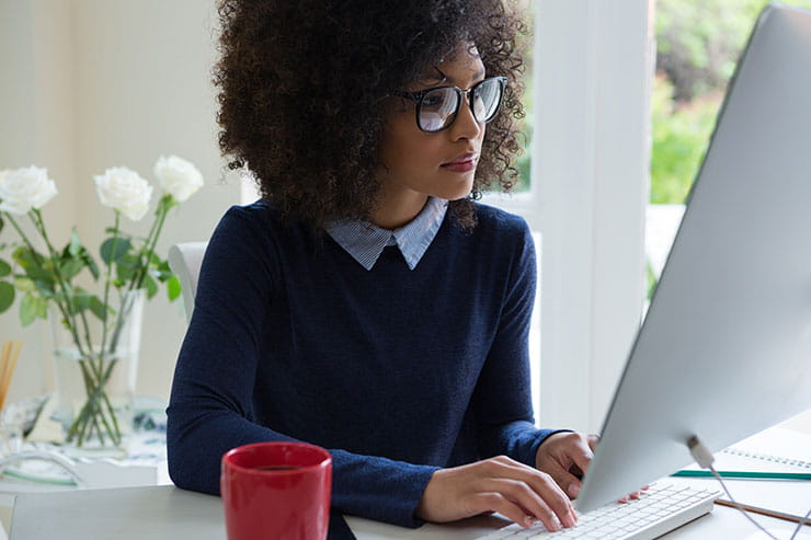 Young woman working on desktop pc at desk