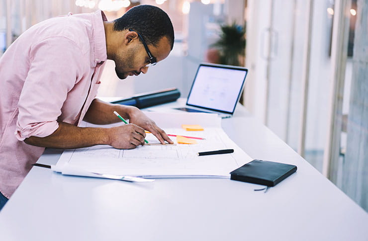 Personne travaillant sur un plan à son bureau